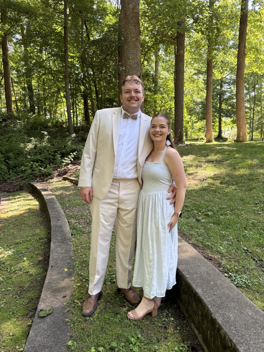 Myers and a companion standing together outdoors among tall trees