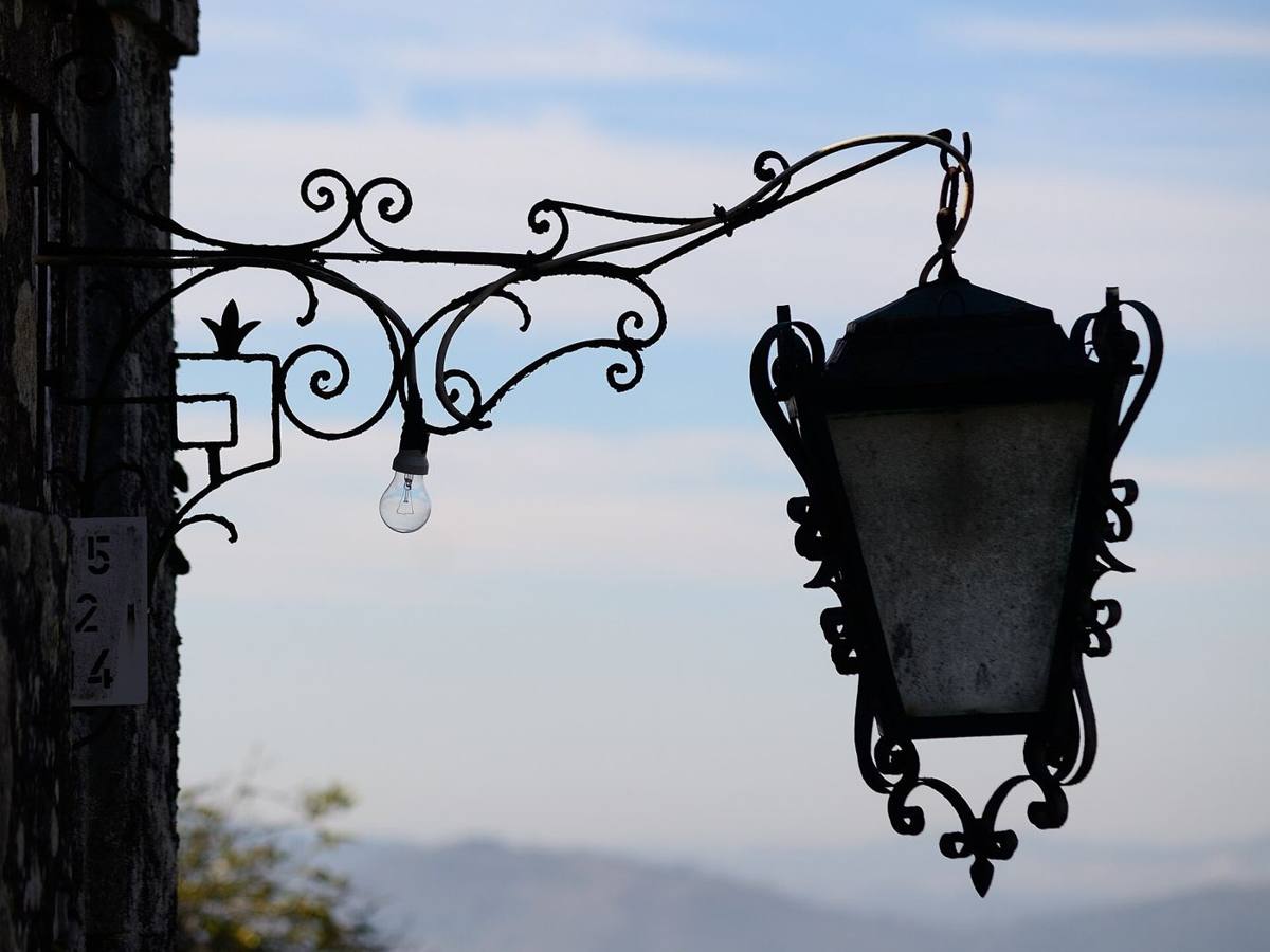 A wrought-iron lantern hanging against the sky