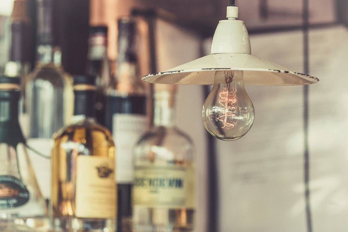 A glowing light bulb under a white pendant shade