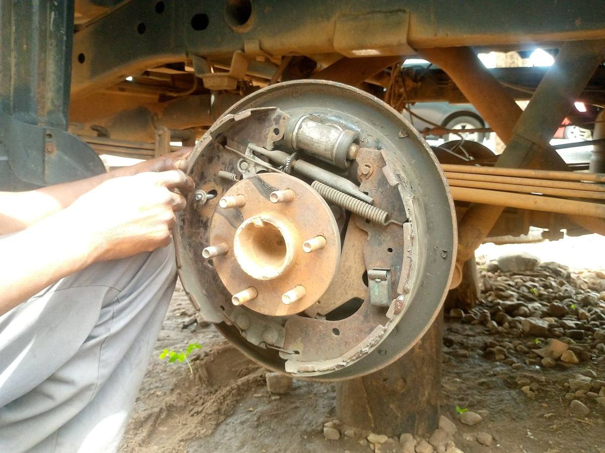 Hands working on a brake drum assembly